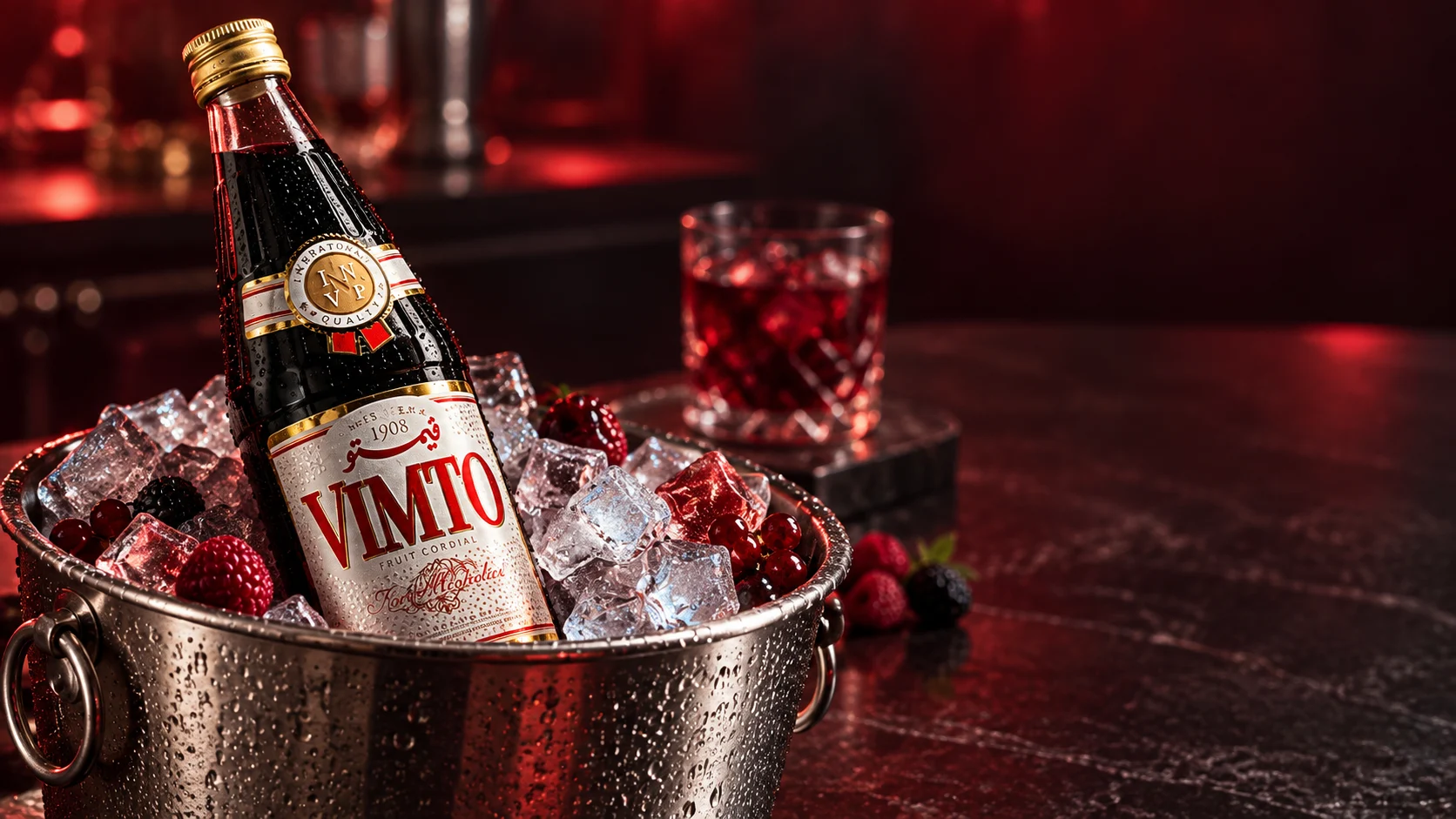 Bouteille de sirop Vimto dans un seau rempli de glace, avec des fruits rouges.